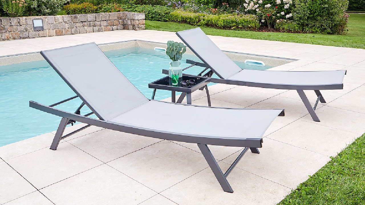 Transat jardin en aluminium à dossier incliné installé sur une terrasse en bois