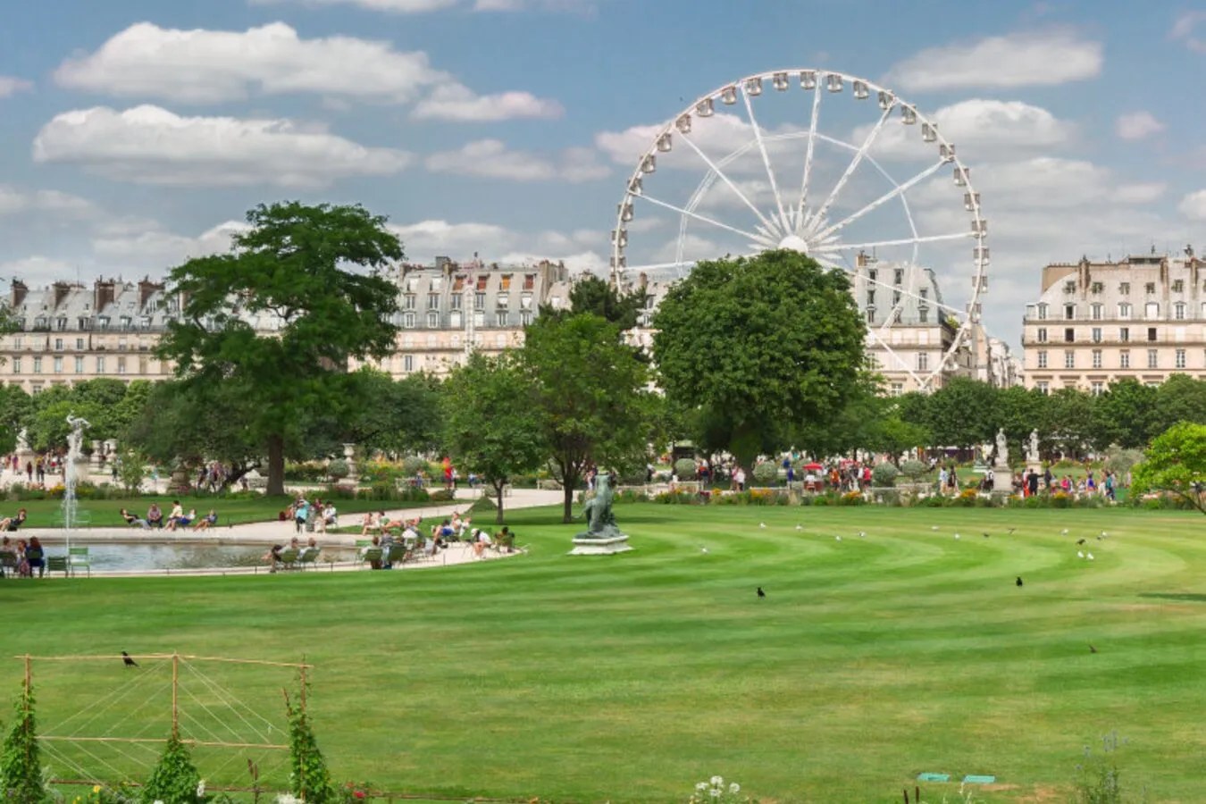 Allée centrale et bassin du jardin des Tuileries à Paris avec le musée du Louvre en arrière-plan