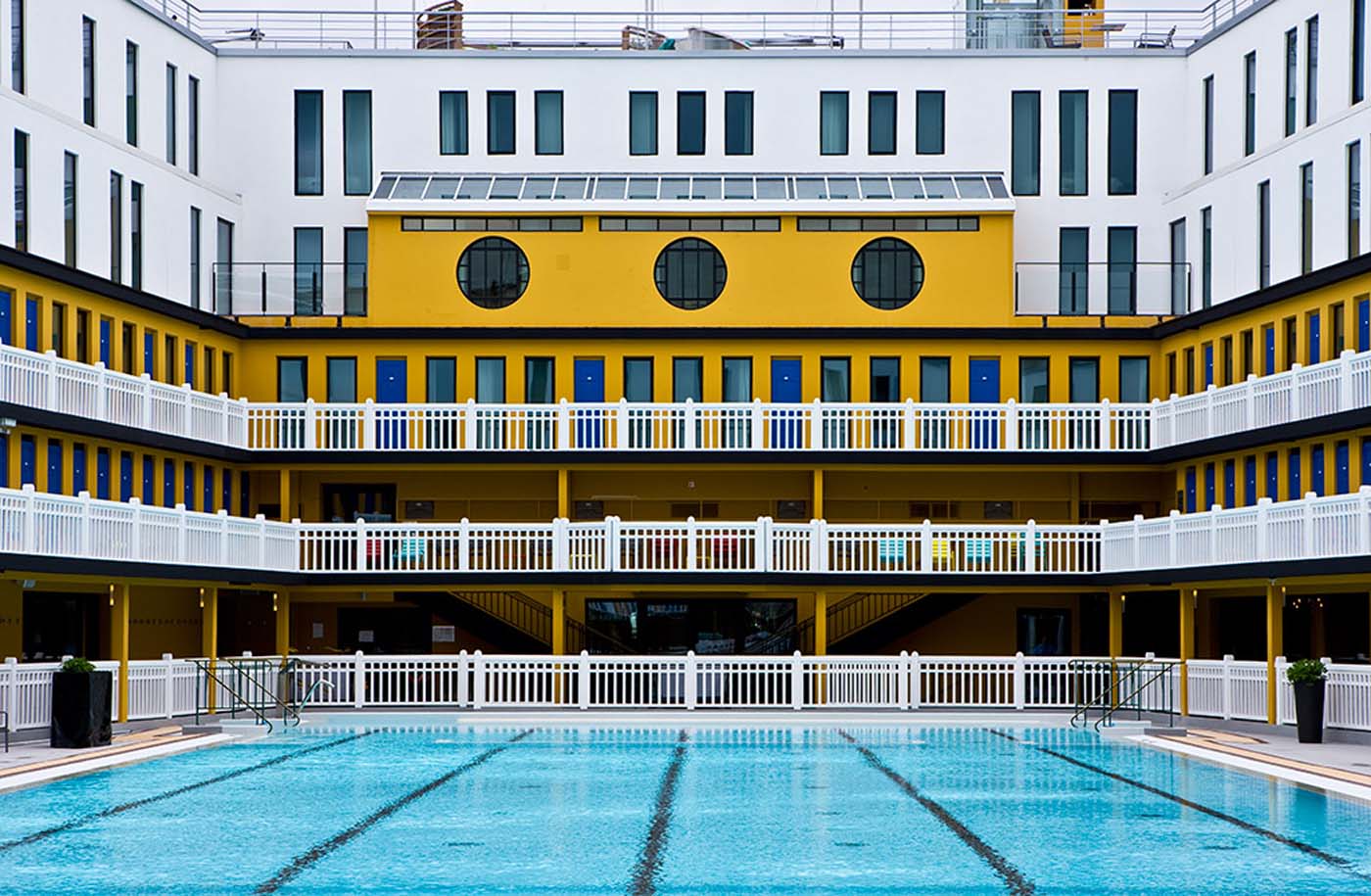 Bassin de la piscine Molitor à Paris entouré de ses galeries Art déco jaunes et blanches
